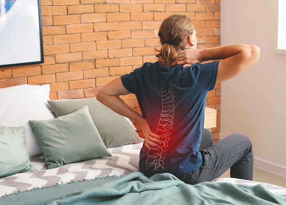 Young man suffering from back pain at home